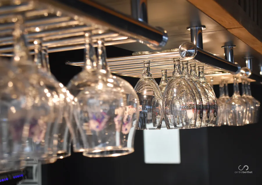 Verres suspendus au-dessus du comptoir du snack bar Terra Padel